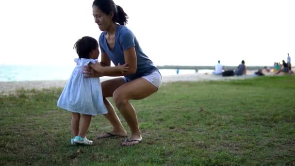 Asijská matka a dcera se lepení baví na pláži — Stock video