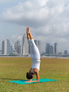 Açık havada Singapur'da Yoga pratik Asyalı Çinli kadın