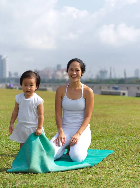 Asiatico cinese donna praticare yoga all'aperto con la giovane bambina — Foto Stock