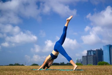 Sportif Asyalı Çinli kadın yogacı güneşin altında egzersiz yapıyor.