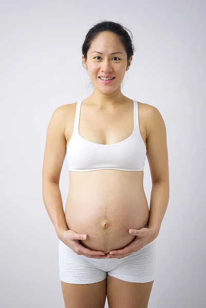 Ευτυχισμένη Ασιάτισσα Κινέζα Που Κρατάει Την Έγκυο Κοιλιά Της Στο — Φωτογραφία Αρχείου