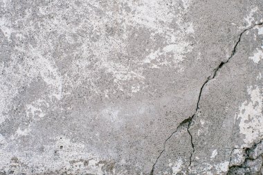 Beton duvar ile yüzey üzerinde derin siyah gri büyük çatlamak. Duvar doku parçası gri ve beyaz yamalar ile yakından.