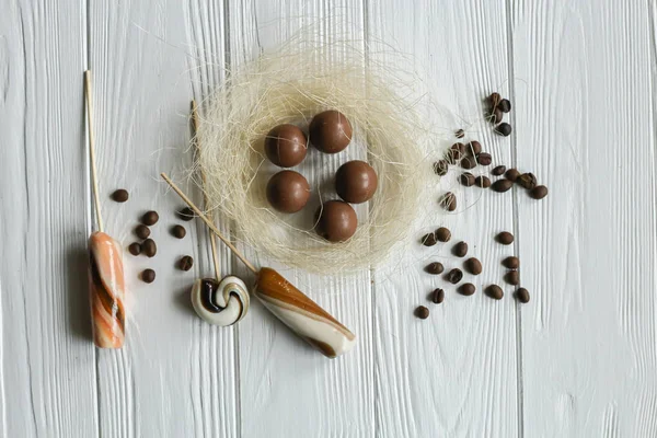 Conjunto de granos de café y dulces de chocolate. Fondo de madera blanca. Espacio para texto — Foto de Stock