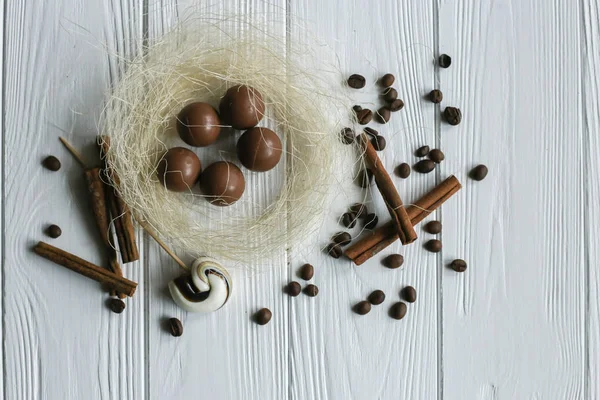 Набір кавових зерен та шоколадних цукерок. Білий дерев'яний фон. Простір для тексту — стокове фото