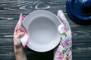 Mutfak Tekstil ve koyu gri ahşap arka plan ellerde bir pot dişinin kümesi 