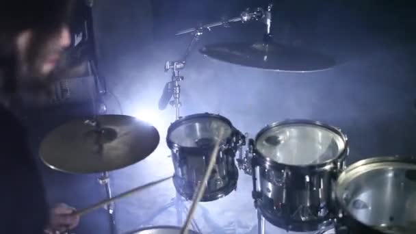 Барабанщик играет на барабанах в темной комнате. Фон дыма — стоковое видео