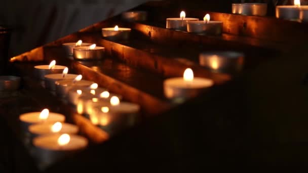 Velas encendidas en el templo en el crepúsculo — Vídeo de stock