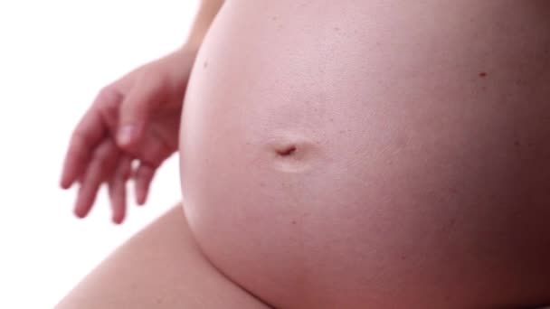 Беременная женщина придает форму сердцу с пальцами на животе — стоковое видео