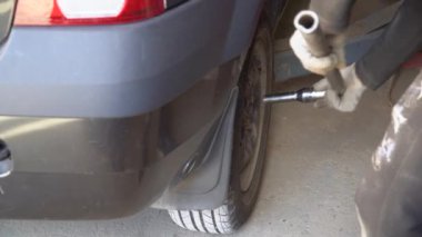 Araba tamirhanesinde profesyonel yolcu vagonunda tekerlek değiştiriyor.