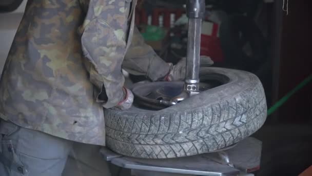 Автомеханик собирает шины на колесах — стоковое видео