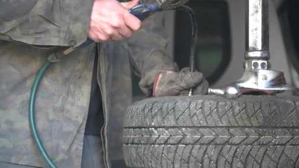 Un hombre bombea un compresor de neumáticos en un taller de reparación de automóviles — Vídeos de Stock