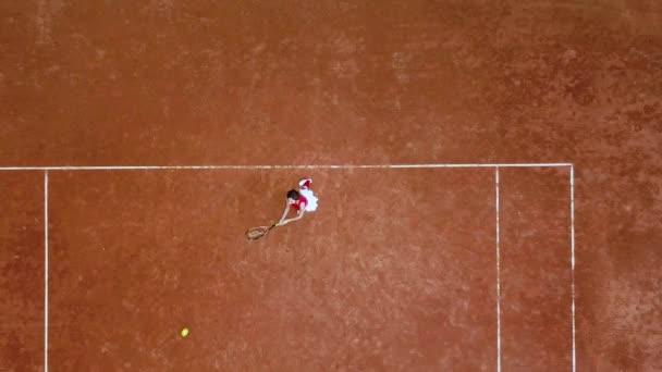 Giovane tennista colpisce una palla da racchetta su un campo da tennis — Video Stock