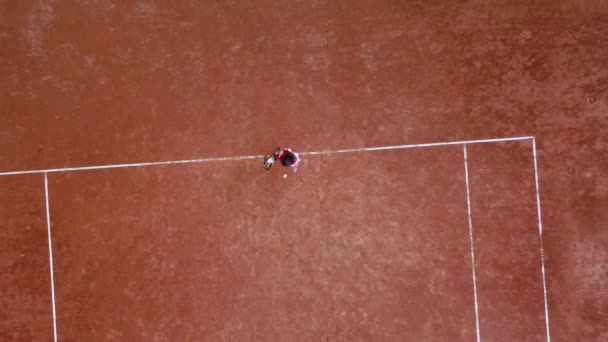 Ung tennisspelare träffar en racket boll på en tennisbana — Stockvideo