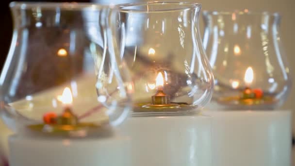Três velas acendem de perto na igreja. Queimar velas em frente ao altar — Vídeo de Stock