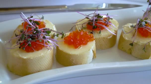 Aperitivo de pão branco, caviar vermelho e micro-greens — Vídeo de Stock