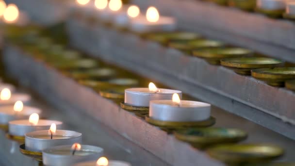 Las velas se encienden de cerca en la iglesia. Velas encendidas frente al altar — Vídeo de stock