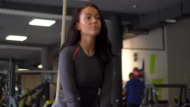 Όμορφη κοπέλα στο αθλητικό σωματείο κάνει διάφορες ασκήσεις στους προσομοιωτές — Αρχείο Βίντεο