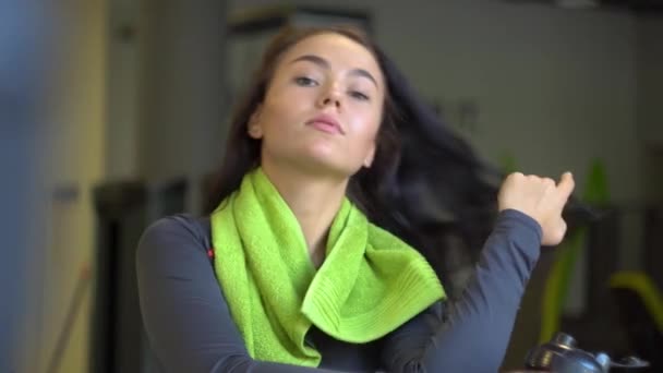 Portret van een jong mooi meisje met een groene handdoek in de sportschool — Stockvideo