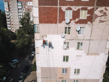 Two industrial climbers warms facade with styrofoam clipart