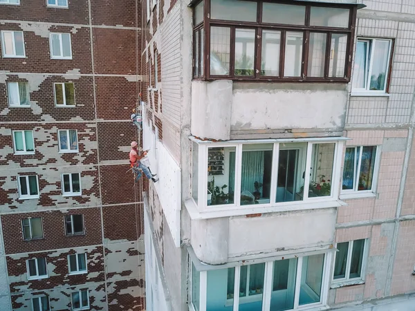 Два промышленных альпиниста греются дома. Рабочие греют фасад здания — стоковое фото