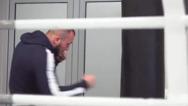 Boxer strajkuje na treningu walki. młody muskularny sportowiec spełnia kopnięcie — Wideo stockowe