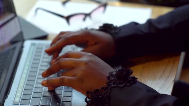 Африканская американская деловая женщина, работающая с ноутбуками и бумагами. Занятая женщина, оплачивающая счета в интернет-банке, управляющая финансами, проверяющая бюджет, выполняющая бумажную работу с помощью компьютера, сидящего за столом — стоковое видео