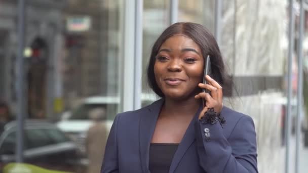 Empresária afro-americana conversando ao telefone com parceiro de negócios — Vídeo de Stock