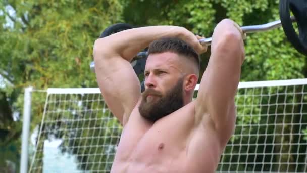 Jeune bodybuilder athlétique barbu fait du sport à l'extérieur. Haltérophilie. Carrosserie — Video