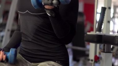 Spor kulübündeki güzel kız simülatörler üzerinde farklı egzersizler yapıyor.