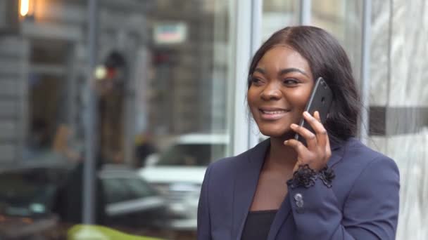 Africká americká podnikatelka mluví po telefonu s obchodním partnerem na Manhattanu — Stock video