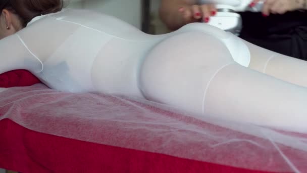 El esteticista hace masajes anticelulíticos a un paciente. Chica en sesión de masaje de GLP en salón de belleza — Vídeos de Stock