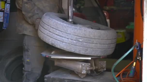 Opravu píchlé pneumatiky z auta mechanikem. Proces vyjmutí pneumatiky z kola ze slitiny pomocí měniče pneumatik. Zimní pneumatiky — Stock video