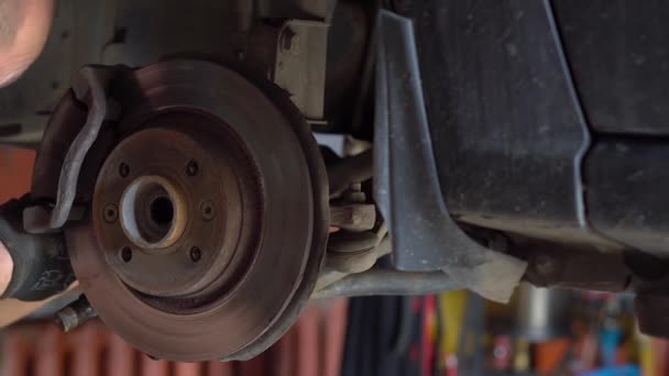 Uomo meccanico riparazione di un'auto in officina di riparazione auto — Video Stock