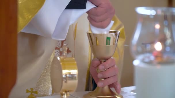 Kilisede mum ışığı yakın. Katolik kilisesinde bir rahip ibadete hazırlanıyor. — Stok video