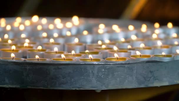 Gyertya fény közelről a templomban. Égő gyertya az oltár előtt — Stock videók