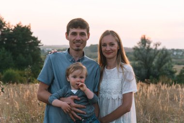 Anne ve baba ve küçük oğlu parkta eğleniyorlar.