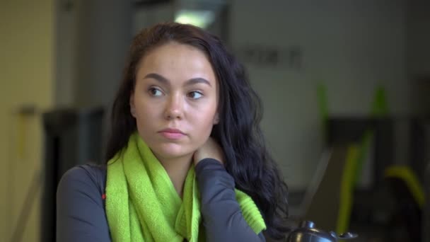 Retrato de una joven hermosa con una toalla verde en el gimnasio — Vídeos de Stock