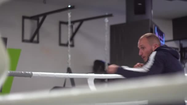 권투 선수가 전투 훈련에서 스트라이크를 치고. 젊은 근력 운동 선수가 발차기를 완수하다 — 비디오