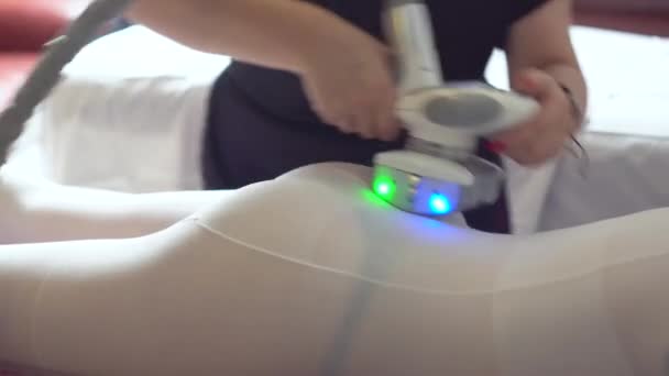 Esteticista faz massagem anti-celulite para um paciente. Menina em sessão de massagem de GLP no salão de beleza — Vídeo de Stock