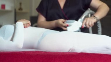 Güzellik uzmanı hastaya anti-selülit masajı yapıyor. Güzellik salonunda Lpg masajı yapan bir kız.
