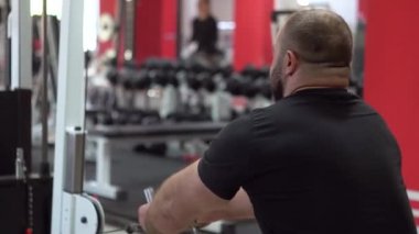 Güçlü kaslı adam spor salonunda farklı egzersizler yapar.