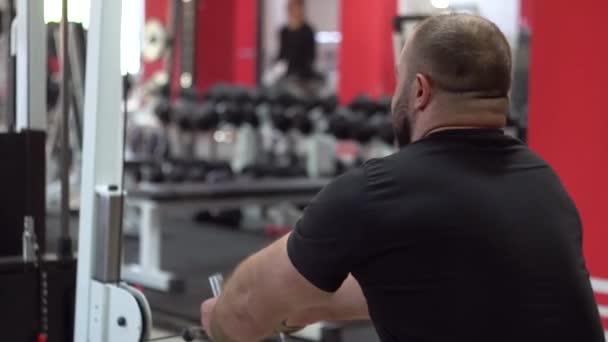 Hombre musculoso fuerte hace diferentes tipos de ejercicios en el gimnasio — Vídeo de stock