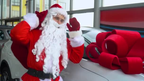 Der Weihnachtsmann im Autohaus. Der Weihnachtsmann kauft ein Geschenkauto — Stockvideo