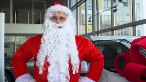 Santa Claus en un concesionario de coches. Santa compra un coche de regalo — Vídeos de Stock