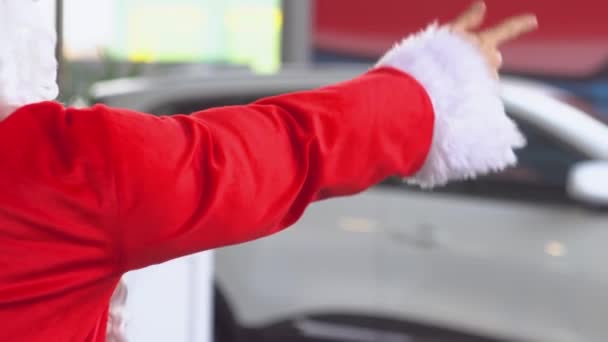 Santa Claus w salonie samochodowym wybiera samochód prezent — Wideo stockowe