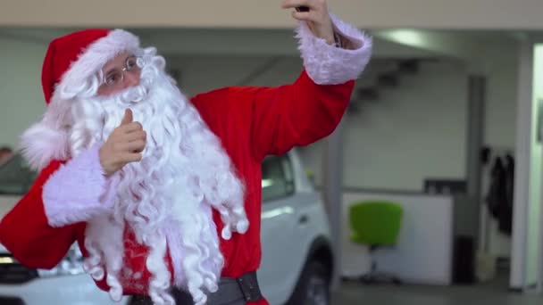 Papai Noel tirar uma selfie em um concessionário de carros e mostrando o gesto "paz " — Vídeo de Stock