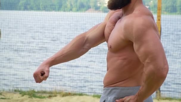 Bodybuilder démontre les muscles. Jeune bodybuilder athlétique barbu fait du sport en plein air — Video