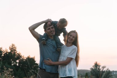 Anne ve baba ve küçük oğlu parkta eğleniyorlar.