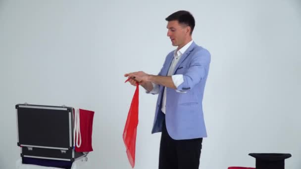 Magician in a suit shows a trick with mirror and shawl on a white background — 비디오