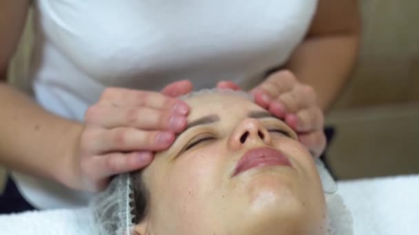 Masajista está haciendo masaje manual en la cara de los clientes. Tratamiento de belleza facial. Spa masaje facial — Vídeos de Stock